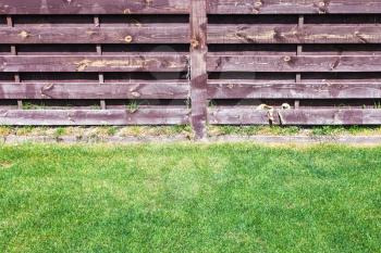 clipped lawn near wooden fence on backyard of country house