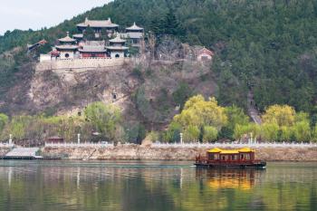 travel to China - temples on East Hill of Chinese Buddhist monument Longmen Grottoes (Dragon's Gate Grottoes, Longmen Caves) on Yi river in spring season