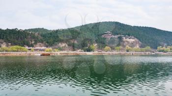 travel to China - panoramic view of East Hill with pagoda of Chinese Buddhist monument Longmen Grottoes (Dragon's Gate Grottoes, Longmen Caves) on Yi river in spring season.