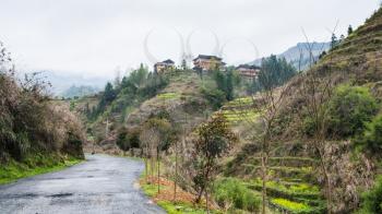 travel to China - wet road and view of Dazhai village in area of Longsheng Rice Terraces (Dragon's Backbone terrace, Longji Rice Terraces) in spring season