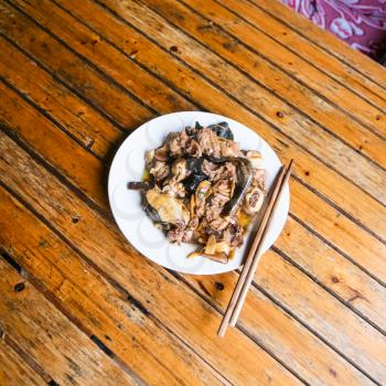 travel to China - top view of chicken with mushrooms on plate in rustic eatery in area Dazhai Longsheng Rice Terraces (Dragon's Backbone terrace, Longji Rice Terraces) country in spring