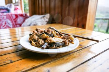 travel to China - plate with chicken and mushrooms in rustic eatery in area Dazhai Longsheng Rice Terraces (Dragon's Backbone terrace, Longji Rice Terraces) country in spring