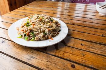travel to China - served fried rice with vegetables on plate in rustic eatery in area Dazhai Longsheng Rice Terraces (Dragon's Backbone terrace, Longji Rice Terraces) country in spring