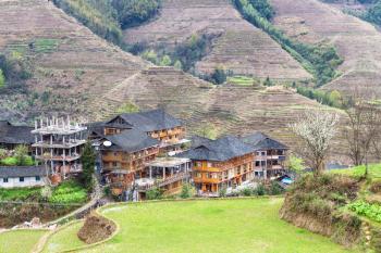 travel to China - view of houses in village between terraced hills of Dazhai Longsheng Rice Terraces (Dragon's Backbone terrace, Longji Rice Terraces) country