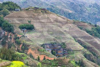 travel to China - view of houses in village on slope of terraced hill of Dazhai Longsheng Rice Terraces (Dragon's Backbone terrace, Longji Rice Terraces) country