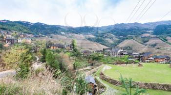 travel to China - view of village and viewpoint Golden Buddha Peak on terraced hills from Seven Stars Chase The Moon in Dazhai area Longsheng Rice Terraces (Longji Rice Terraces) country in spring
