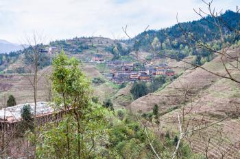 travel to China - view of Dazhai village from green hills in area Longsheng Rice Terraces (Longji Rice Terraces) in spring