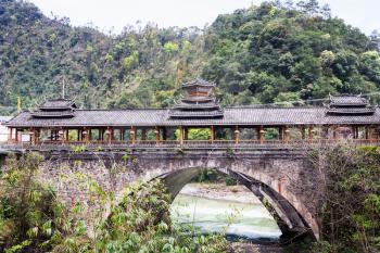 travel to China - view of Dong people style bridge in Jiangdi village over river in Longsheng Hot Springs National Forest Park of Xiangshan District in spring season