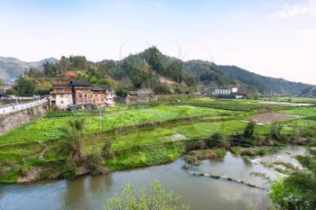 travel to China - view of gardens, rice paddy, tea plantation near river in Chengyang village of Sanjiang Dong Autonomous County in spring season