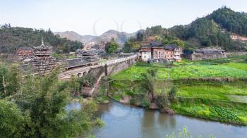 travel to China - view of Bridge and gardens near river in Chengyang village of Sanjiang Dong Autonomous County in spring season