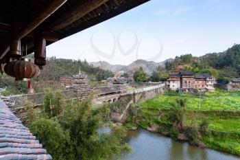 travel to China - view of Wind and Rain Bridge and gardens near river in Chengyang village of Sanjiang Dong Autonomous County in spring season