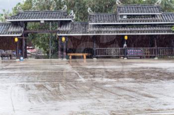 travel to China - raindrops and unfocused gate of main square in Folk Custom Centre of Chengyang village of Sanjiang Dong Autonomous County in spring season