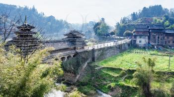 travel to China - view of Fengyu Bridge and gardens near river in Chengyang village of Sanjiang Dong Autonomous County in spring morning
