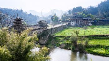 travel to China - view of Dong people Bridge and gardens near river in Chengyang village of Sanjiang Dong Autonomous County in spring morning