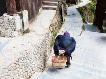 travel to China - a hunched old woman on street in Chengyang village of Sanjiang Dong Autonomous County in spring season