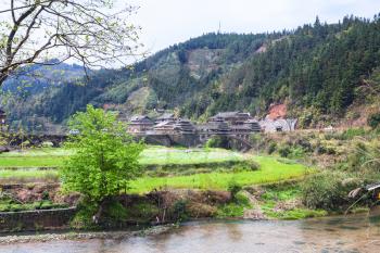 travel to China - view of Chengyang village with Bridge from gardens in area of Sanjiang Dong Autonomous County in spring morning