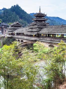 travel to China - covered Chengyang Wind and Rain Bridge over river (Fengyu Bridges of the Dong people) in Sanjiang Dong Autonomous County in spring season