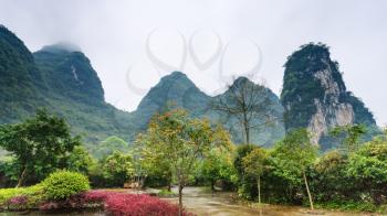 travel to China - square in village and karst mountains in Yangshuo County in spring season