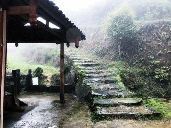 travel to China - wet path near country house in Tiantou village in area Dazhai Longsheng Rice Terraces (Dragon's Backbone terrace, Longji Rice Terraces) in spring rain season