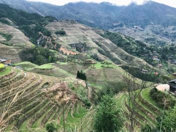 travel to China - view of Dazhai country with villages and terraced rice paddies from viewpoint Seven Stars Chase The Moon in area Longsheng Rice Terraces (Longji Rice Terraces) in spring