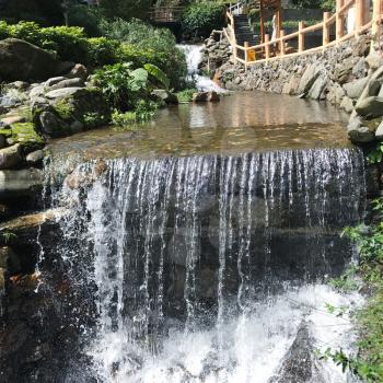 travel to China - waterfall with warm water from hot spring in Jiangdi village in resort area Longsheng Hot Springs National Forest Park of Xiangshan District