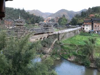 travel to China - view of Wind and Rain Bridge over river in Chengyang village of Sanjiang Dong Autonomous County in spring evening