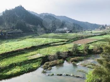travel to China - view of rice fields near river in Chengyang village of Sanjiang Dong Autonomous County in spring evening