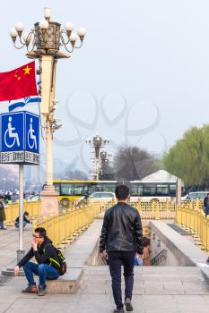BEIJING, CHINA - MARCH 19, 2017: people near underground pedestrian crossing on West Chang'an Avenue on Tiananmen Square in spring. Tiananmen Square is central city square in Beijing