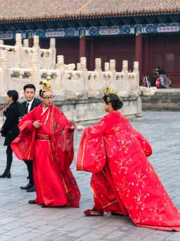 BEIJING, CHINA - MARCH 19, 2017: couple in traditional dresses and photographer on court of Imperial Ancestral Temple (Taimiao, Working People's Cultural Palace) in Beijing Imperial city in spring.