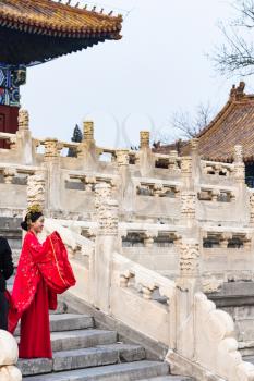 BEIJING, CHINA - MARCH 19, 2017: woman in traditional costume and photographer on court of Imperial Ancestral Temple (Taimiao, Working People's Cultural Palace) in Beijing Imperial city in spring.