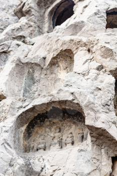 LUOYANG, CHINA - MARCH 20, 2017: caves with reliefs in Chinese Buddhist monument Longmen Grottoes (Longmen Caves). The complex was inscribed upon the UNESCO World Heritage List in 2000