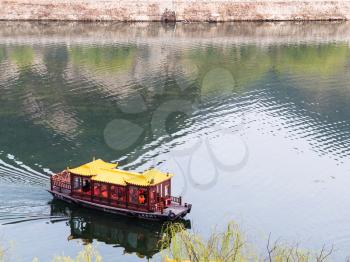 LUOYANG, CHINA - MARCH 20, 2017: boat on Yi river between West and East Hills of Chinese Buddhist monument Longmen Grottoes ( Longmen Caves) in spring season