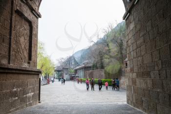 LUOYANG, CHINA - MARCH 20, 2017: visitors near gate to Chinese Buddhist monument Longmen Grottoes (Longmen Caves) in spring. The complex was inscribed upon the UNESCO World Heritage List in 2000