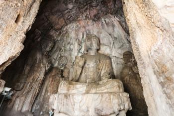 LUOYANG, CHINA - MARCH 20, 2017: Sculptures in grotto in Chinese Buddhist monument Longmen Grottoes (Longmen Caves). The complex was inscribed upon the UNESCO World Heritage List in 2000