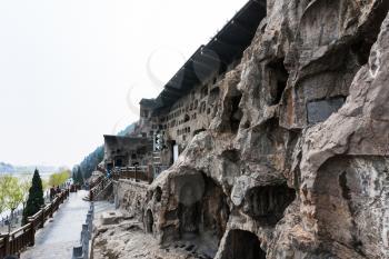 LUOYANG, CHINA - MARCH 20, 2017: tourists near caves and Grottoes in West Hill of Chinese Buddhist monument Longmen Grottoes. The complex was inscribed upon the UNESCO World Heritage List in 2000