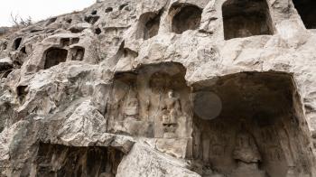 LUOYANG, CHINA - MARCH 20, 2017: carved wall of grotoes in West Hill of Chinese Buddhist monument Longmen Caves. The complex was inscribed upon the UNESCO World Heritage List in 2000