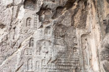 LUOYANG, CHINA - MARCH 20, 2017: relief on wall of cave in West Hill of Chinese Buddhist monument Longmen Grottoes. The complex was inscribed upon the UNESCO World Heritage List in 2000