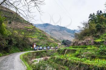 DAZHAI, CHINA - MARCH 23, 2017: cars on parking lot near Dazhai Longsheng village in spring. This is central village in famous scenic area of Longji Rice Terraces in China