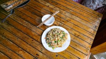 travel to China - above view of fried rice with vegetables on plate in rustic eatery in area Dazhai Longsheng Rice Terraces (Dragon's Backbone terrace, Longji Rice Terraces) country in spring