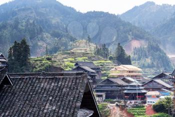 CHENGYANG, CHINA - MARCH 27, 2017: view of country houses in Chengyang village and hills of Sanjiang Dong Autonomous County in spring. Chengyang district includes eight villages of the Dong people