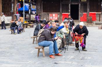 CHENGYANG, CHINA - MARCH 27, 2017: visitors and gift seller on square of Folk Custom Centre of Chengyang village of Sanjiang County in spring. Chengyang includes eight villages of Dong people