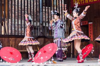 CHENGYANG, CHINA - MARCH 27, 2017: folk actors with umbrellas in Dong Culture Show in Folk Centre of Chengyang village of Sanjiang County in spring. Chengyang includes eight villages of Dong people