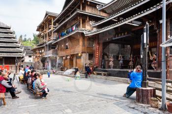 CHENGYANG, CHINA - MARCH 27, 2017: tourists and Dong Culture Show on square of Folk Custom Centre of Chengyang village of Sanjiang County in spring. Chengyang includes eight villages of Dong people