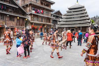 CHENGYANG, CHINA - MARCH 27, 2017: tourists and actors on square of Folk Custom Centre during Dong Culture Show of Chengyang village Sanjiang County. Chengyang includes eight villages of Dong people
