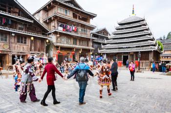CHENGYANG, CHINA - MARCH 27, 2017: visitors in round dance on square of Folk Custom Centre during Dong Culture Show in Chengyang village in spring. Chengyang includes eight villages of the Dong people