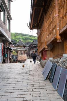 CHENGYANG, CHINA - MARCH 27, 2017: woman on alley in Chengyang village of Sanjiang Dong Autonomous County in spring. Chengyang includes eight villages of the Dong people