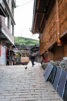 CHENGYANG, CHINA - MARCH 27, 2017: old woman on alley in Chengyang village of Sanjiang Dong Autonomous County in spring. Chengyang includes eight villages of the Dong people