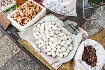 YANGSHUO, CHINA - MARCH 30, 2017: eggs, gingers, chestnuts on street outdoor market in Yangshuo in spring. Town is resort destination for domestic and foreign tourists because of scenic karst peaks