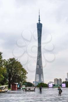 GUANGZHOU, CHINA - MARCH 31, 2017: tourists on square in Zhujiang New Town of Guangzhou city in rainy day and Guangzhou (Canton) TV Astronomical and Sightseeing Tower. The tower was topped out in 2009