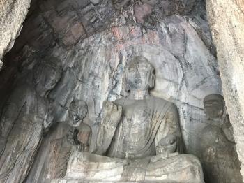 LUOYANG, CHINA - MARCH 20, 2017: carved statues in grotto in Chinese Buddhist monument Longmen Grottoes (Longmen Caves). The complex was inscribed upon the UNESCO World Heritage List in 2000